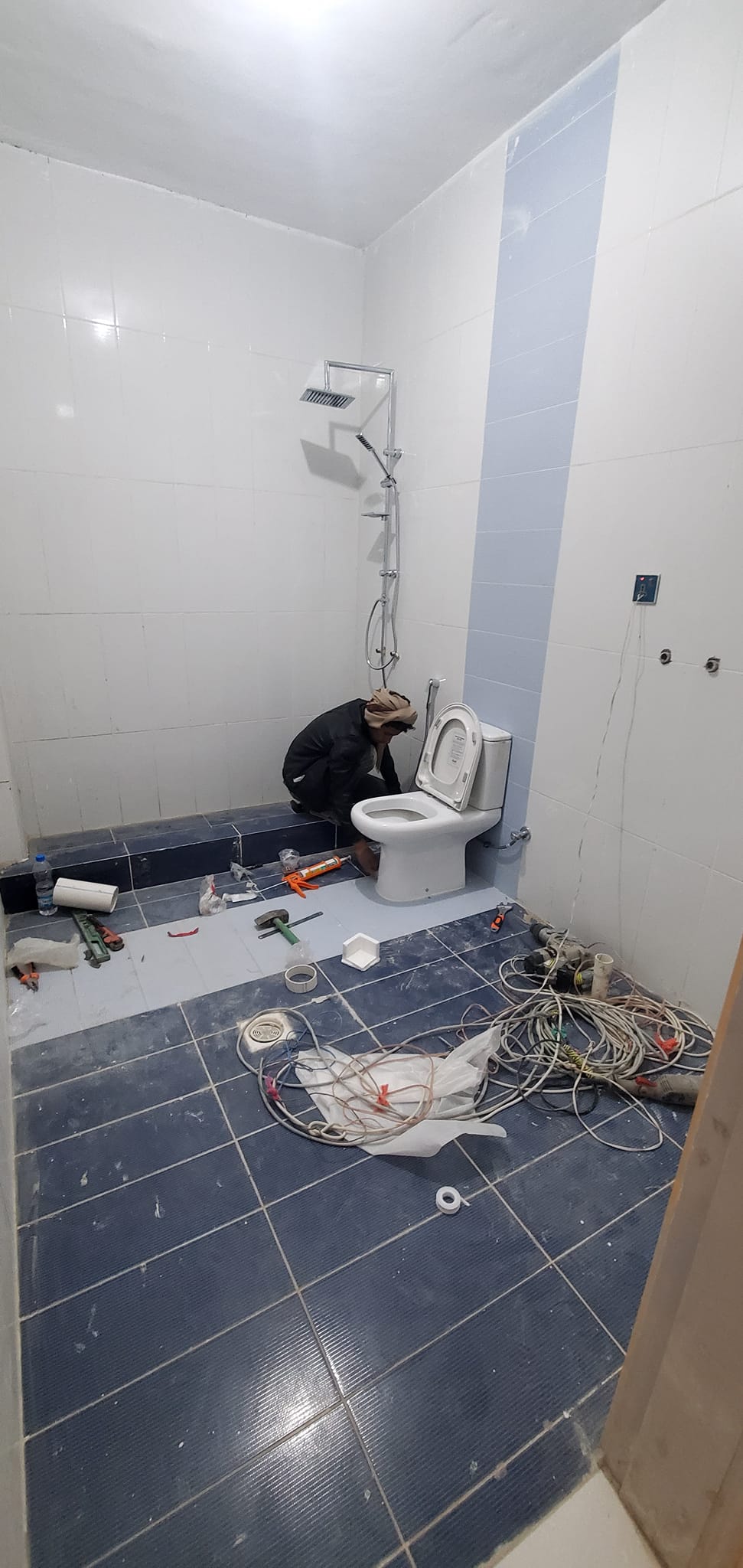جانب من أعمال تركيب المواد الصحية وخزانات وشبكة النزول للمياة في المبنى (أ)