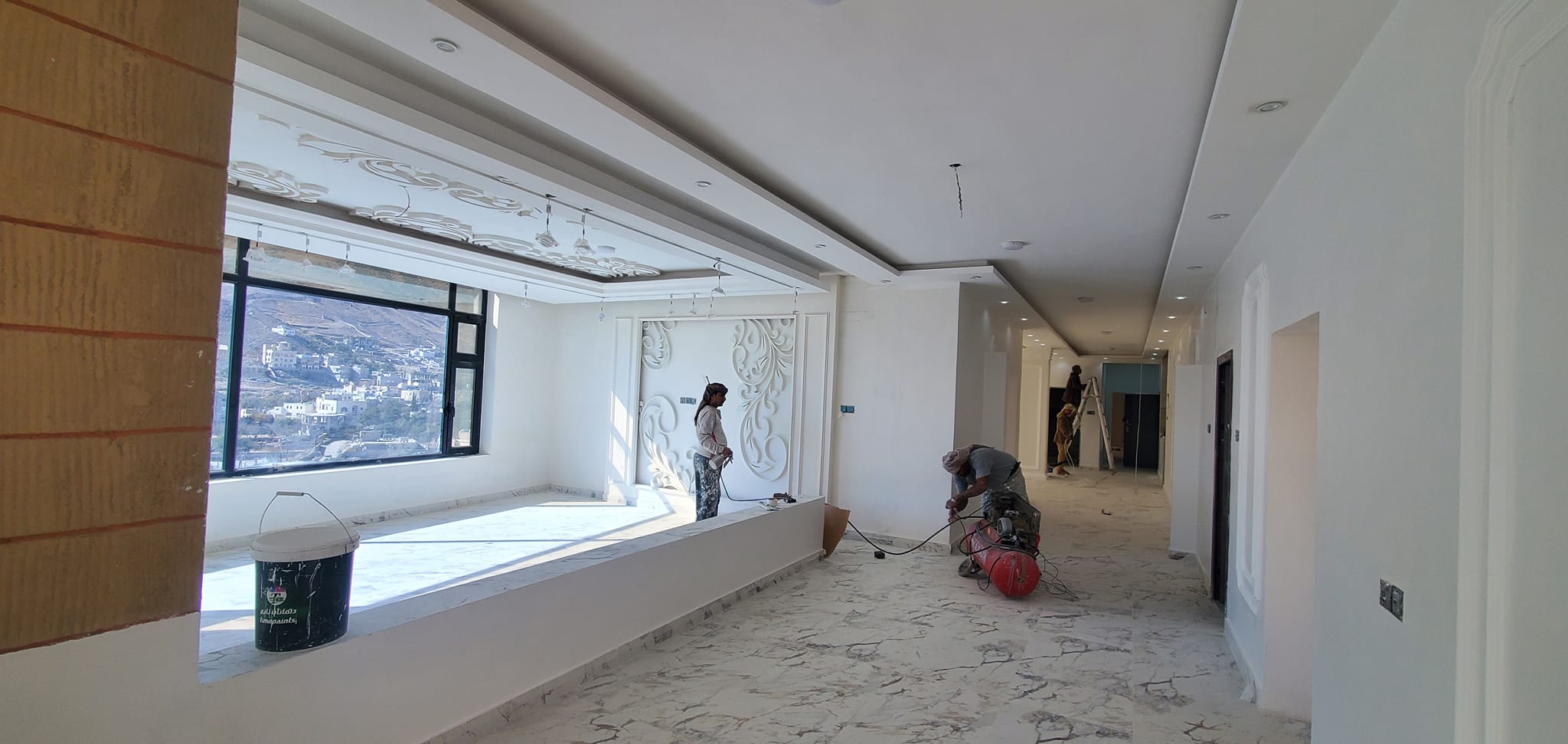 جانب من أعمال الدهان الزيتي النهائي للشقق في المبنى (أ).